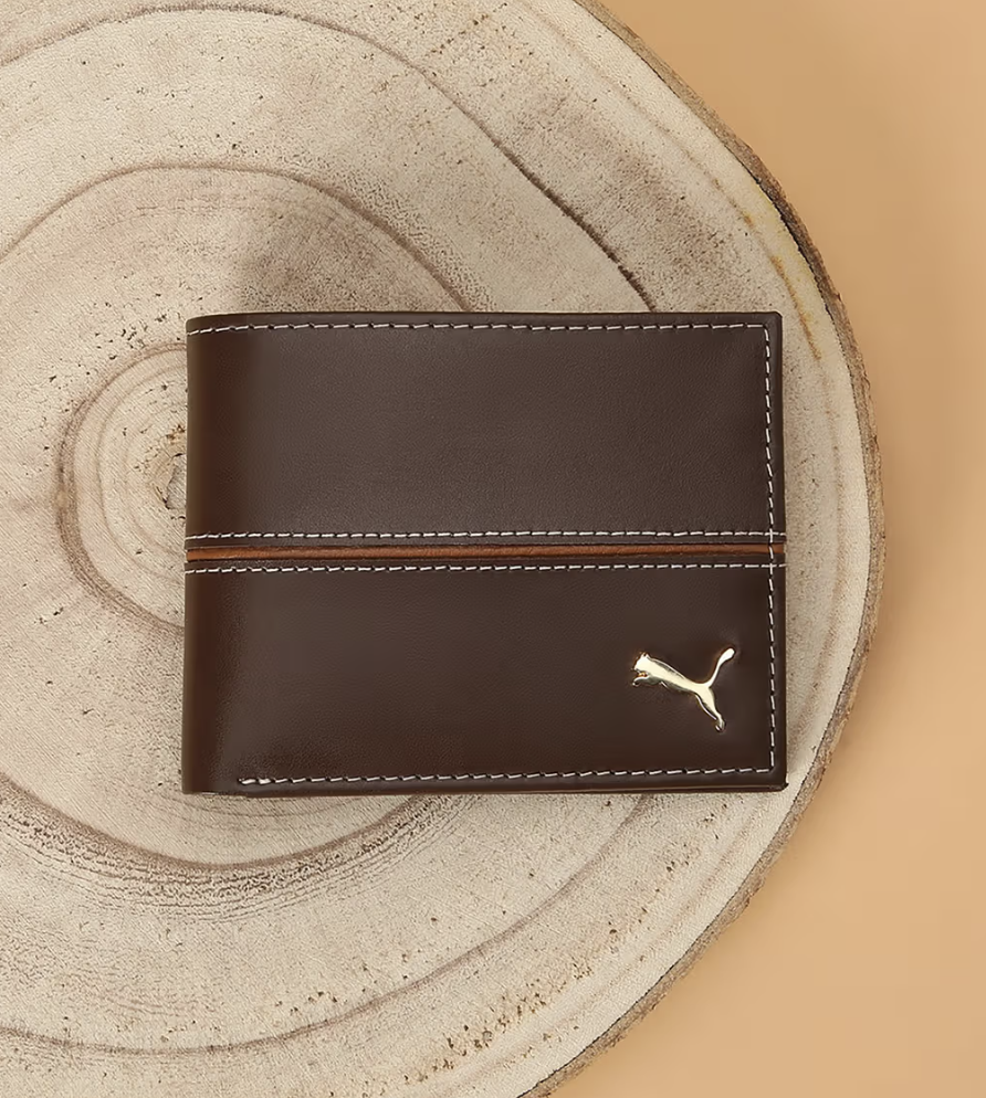 a brown wallet sitting on top of a wooden table