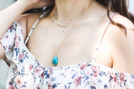 Summer Necklace - Gold Turquoise Accessory featuring a double-chained design with a turquoise pendant and gold accent, worn with a floral dress.